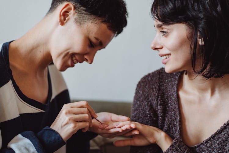 Couple Smiling And Painting Nails