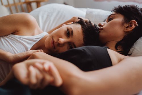 Free A tender moment capturing a loving couple embracing intimately in bed, conveying warmth and affection. Stock Photo