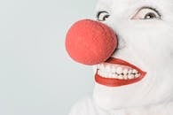 Smiling Person With Pink Lipstick and Red Nose Clown