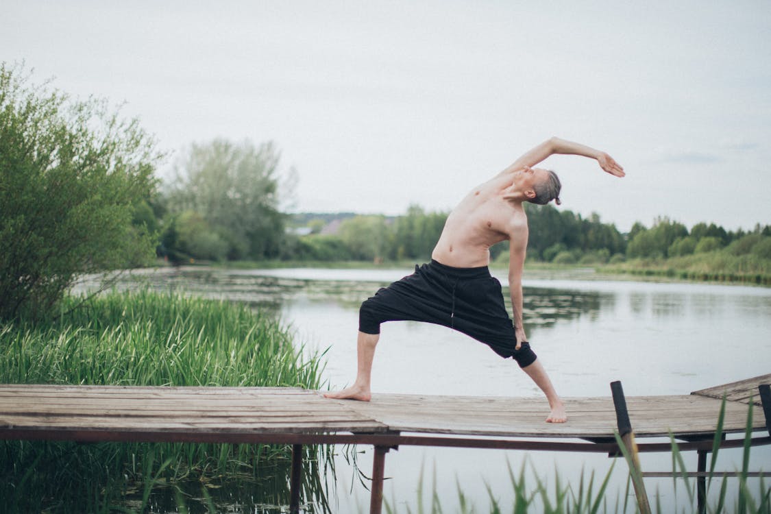 A Man Stretching Beside the Lake