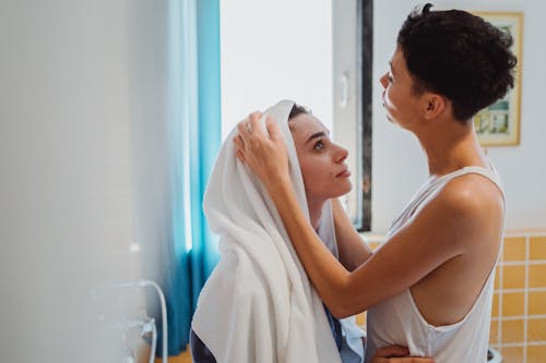 Woman Drying Another Woman's Hair with a Towel