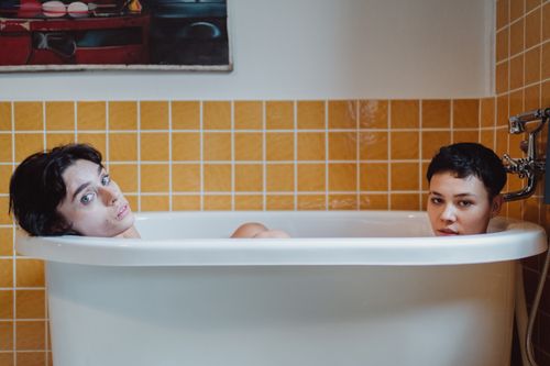 Free Couple enjoying a relaxing moment in a stylish bathtub setting. Stock Photo