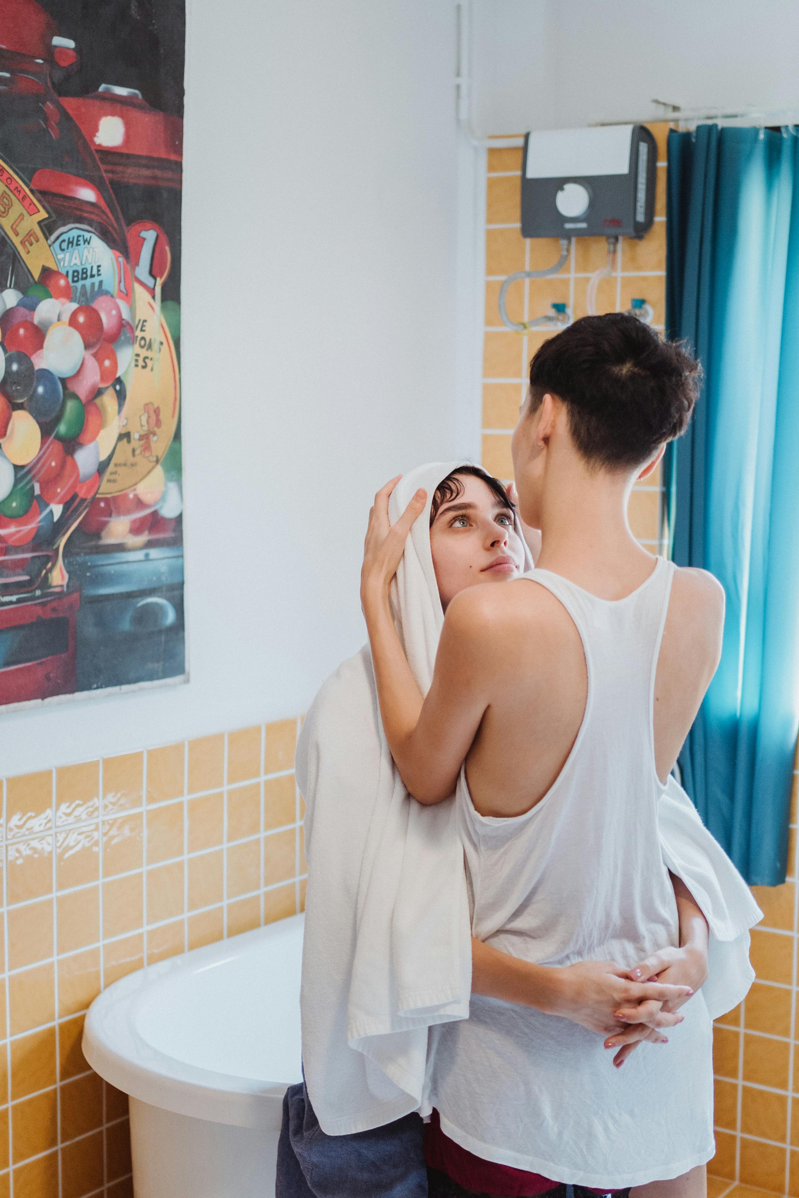 woman drying another woman s hair with a towel