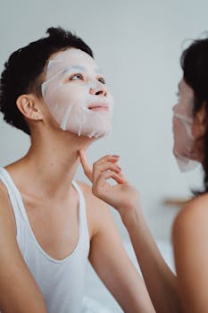 A couple with face masks enjoying a pampering skincare routine together indoors.