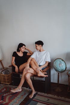 一对夫妇赤脚坐在室内的长凳上，在靠近地球仪的地方放松