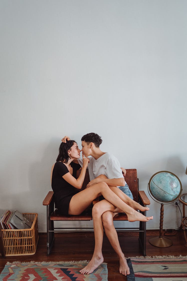 Women Sitting On Chair Leaning In For Kiss