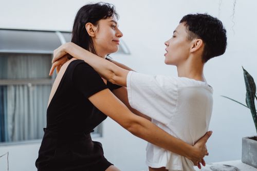 Free A tender moment between two women embracing and looking into each other's eyes indoors. Stock Photo
