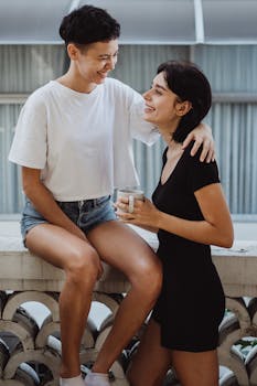 A happy same-sex couple embracing on a balcony, sharing a moment with coffee.