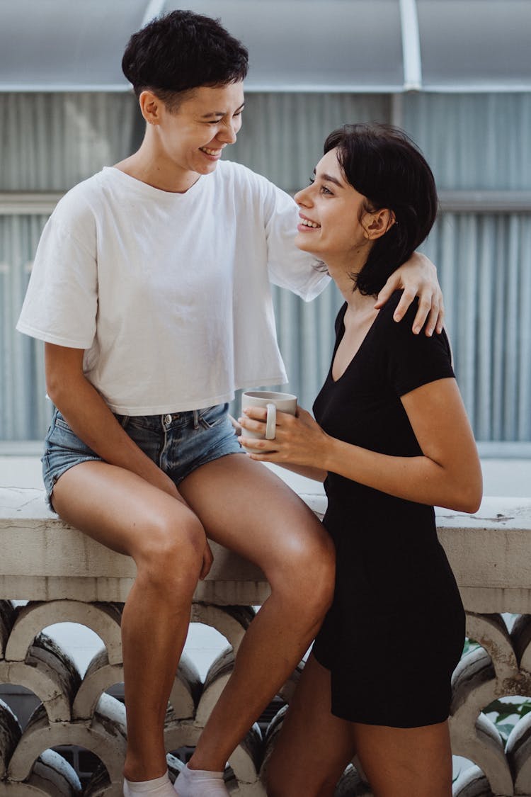 Women Talking And Drinking Coffee On Balcony