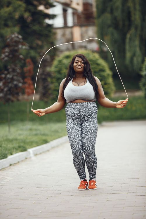Free Woman exercising outdoors with a jump rope, promoting fitness and health. Stock Photo