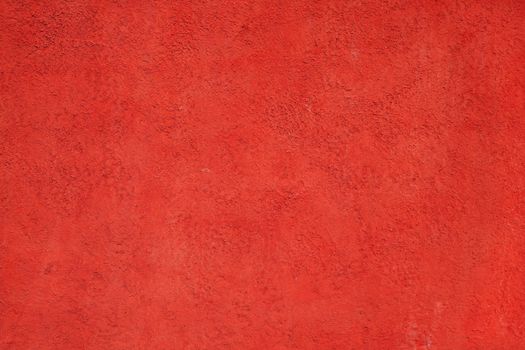 Detailed red concrete wall texture creating a vibrant background with a rough surface.