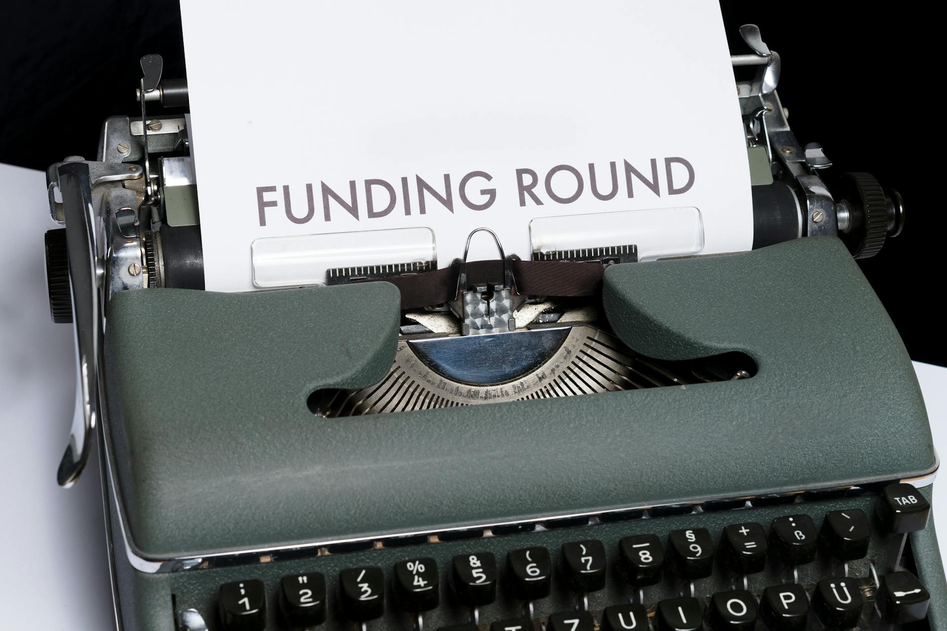 A vintage typewriter displaying the text 'Funding Round,' symbolizing investment and business planning.