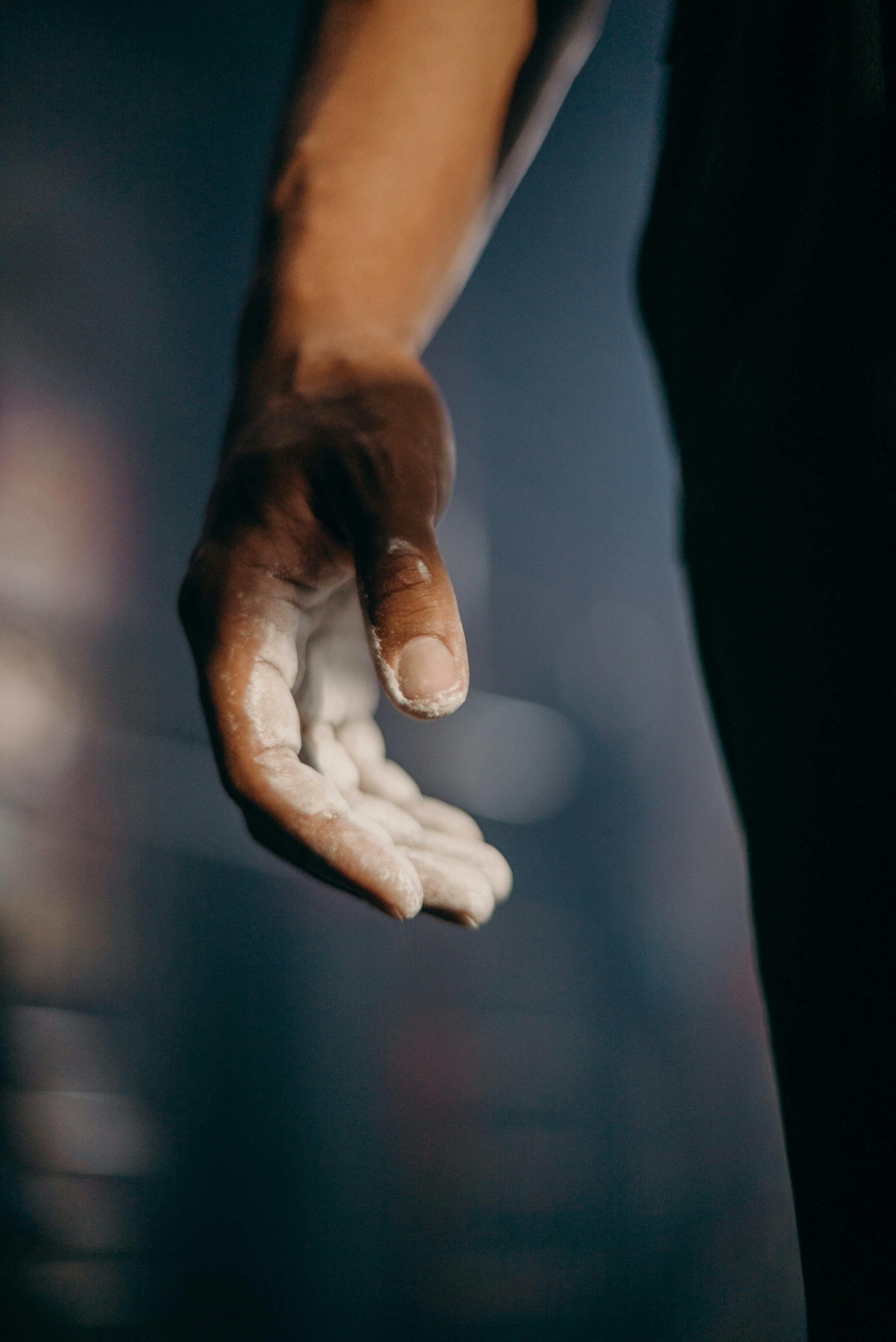 A detailed shot of an athlete's hand covered in chalk, ready for training in the gym.