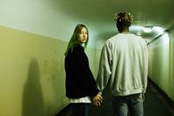 Man in Gray Sweater Standing Beside Woman in Black Jacket