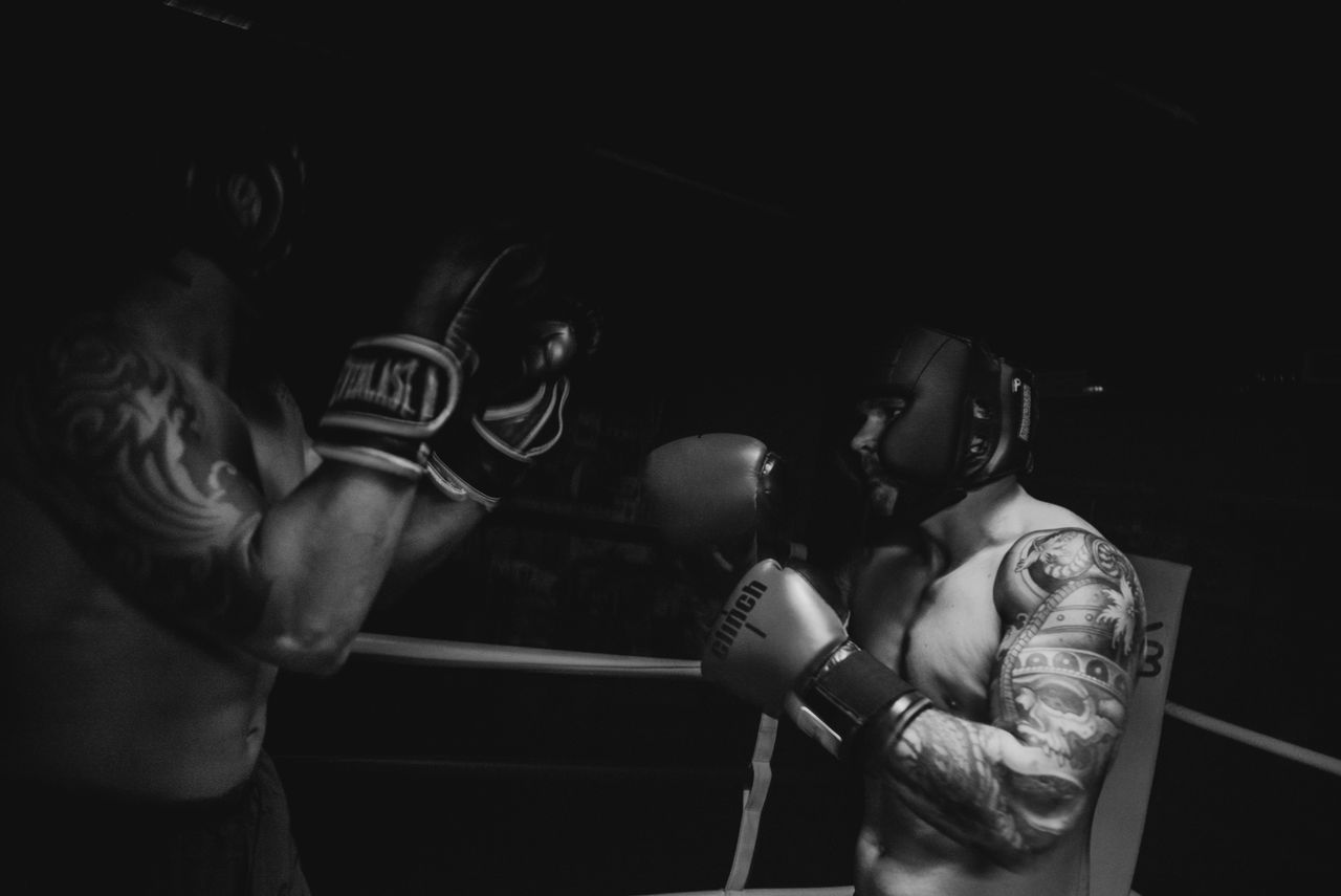 black and white photo of two boxers sparring in a dimly lit gym showca
