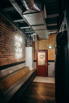 Cozy industrial-style gym locker room featuring a punching bag and neon light decor.