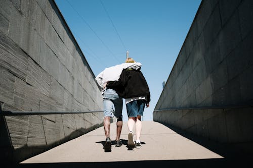 Wanita Dengan Jaket Hitam Dan Celana Pendek Denim Biru Berjalan Di Trotoar