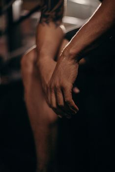 Detailed close-up of a person's hands with a focus on strength and athleticism in a gym environment.