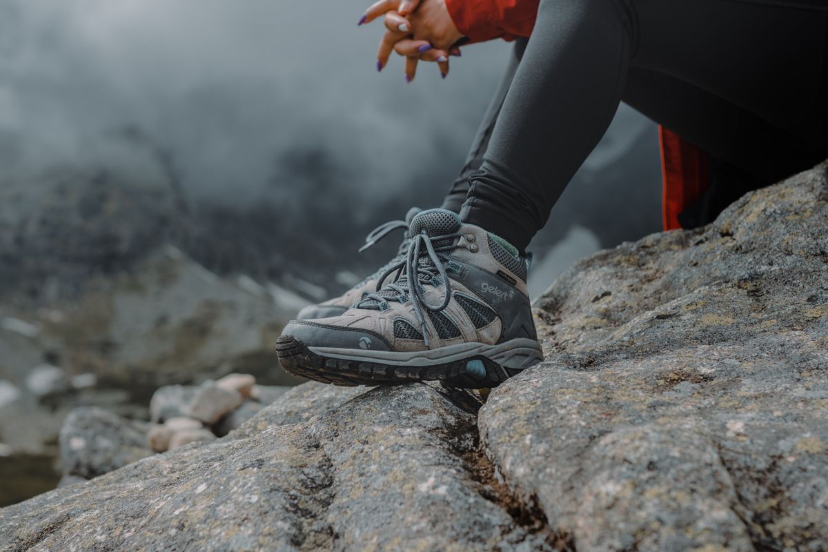 A grey trail shoe on a rocky ledge
