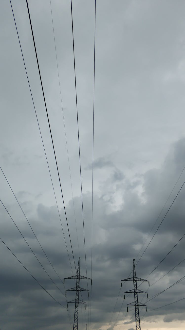 Overhead Power Line On Cloudy Sky At Dusk