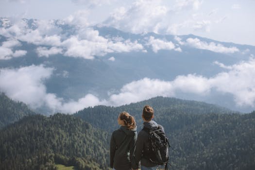 A couple enjoying a breathtaking mountain view while hiking in nature.
