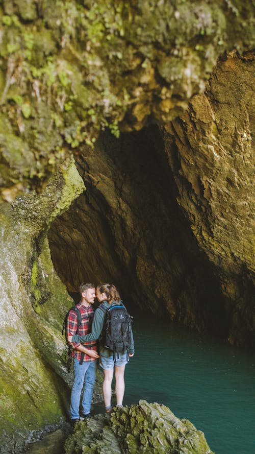 Couple Standing Near the Cave Entrance