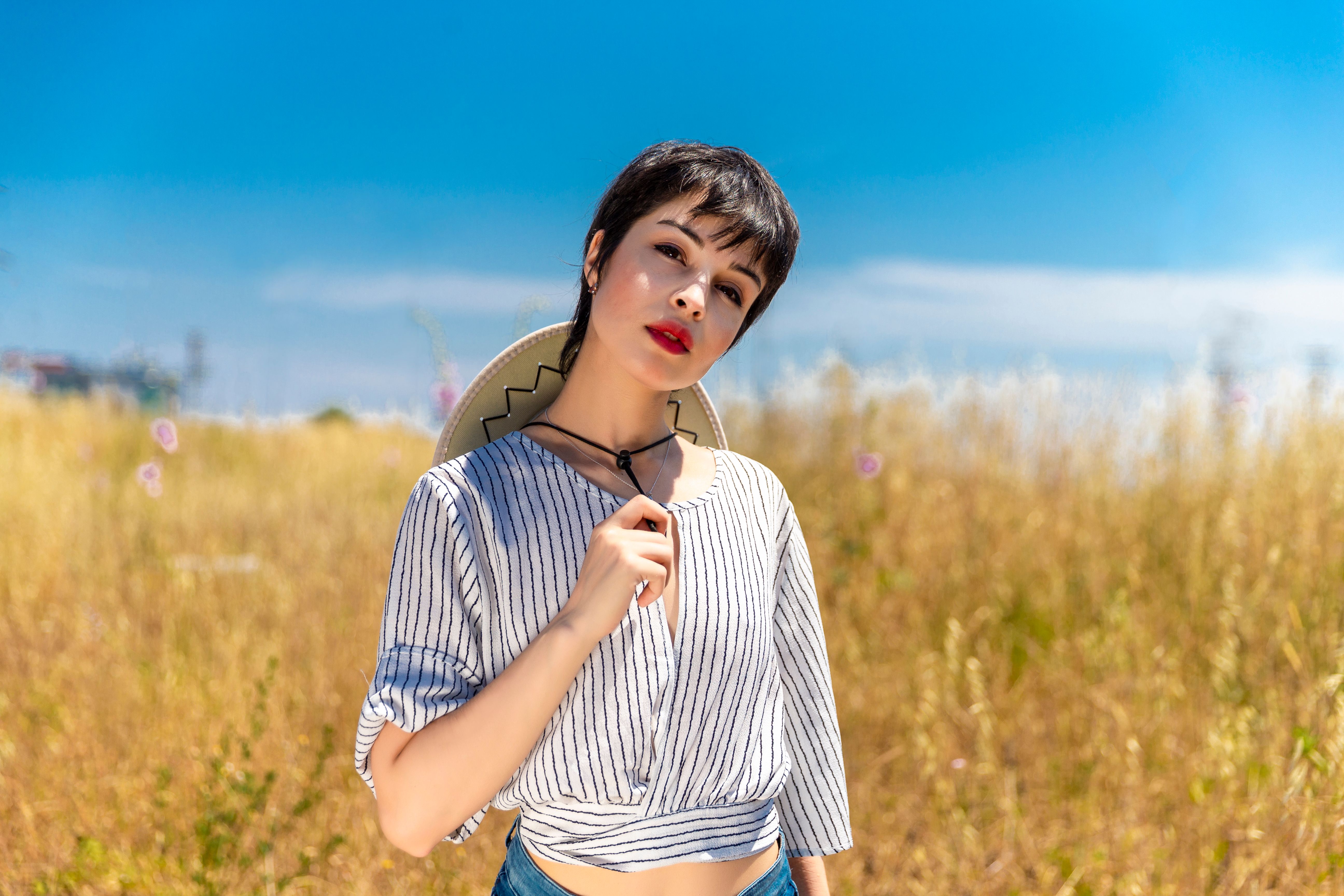 Woman in White and Black Stripe Shirt Standing on Green Grass Field ...
