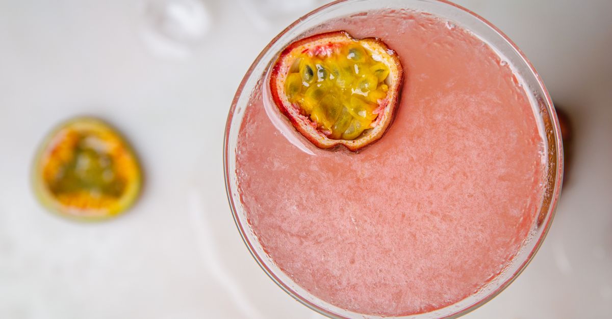 Top view of a vibrant passion fruit martini cocktail with fresh garnish.