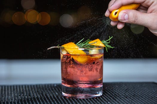 Close-up of a whiskey cocktail with citrus and rosemary, perfect for a refreshing evening drink.