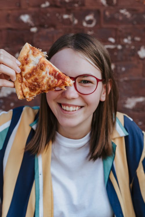 Free Girl Holding a Slice of Pizza Stock Photo