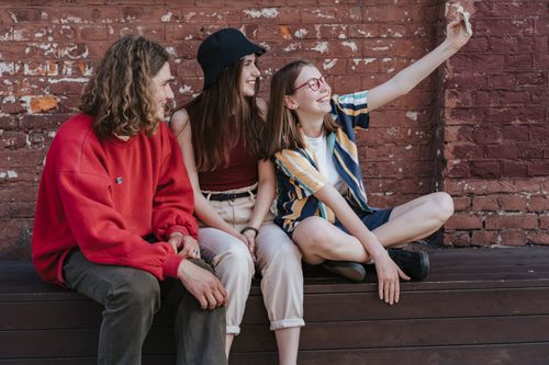Free A group of smiling teenagers taking a selfie against a brick wall in Minsk, Belarus. Stock Photo