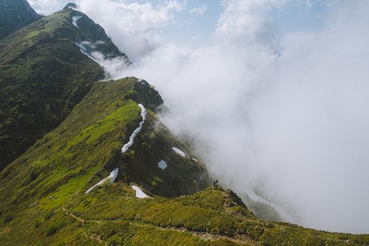 一对夫妇在薄雾笼罩的山脊上徒步旅行，眼前展现出一片壮丽的景色