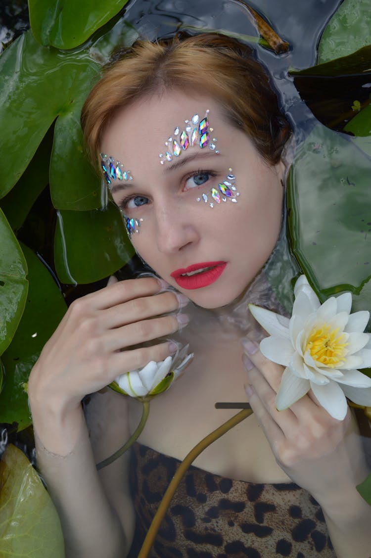 Peaceful Woman Lying In Water With Water Lilies