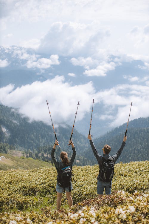 Free Backpackers Holding Their Trekking Poles  Stock Photo