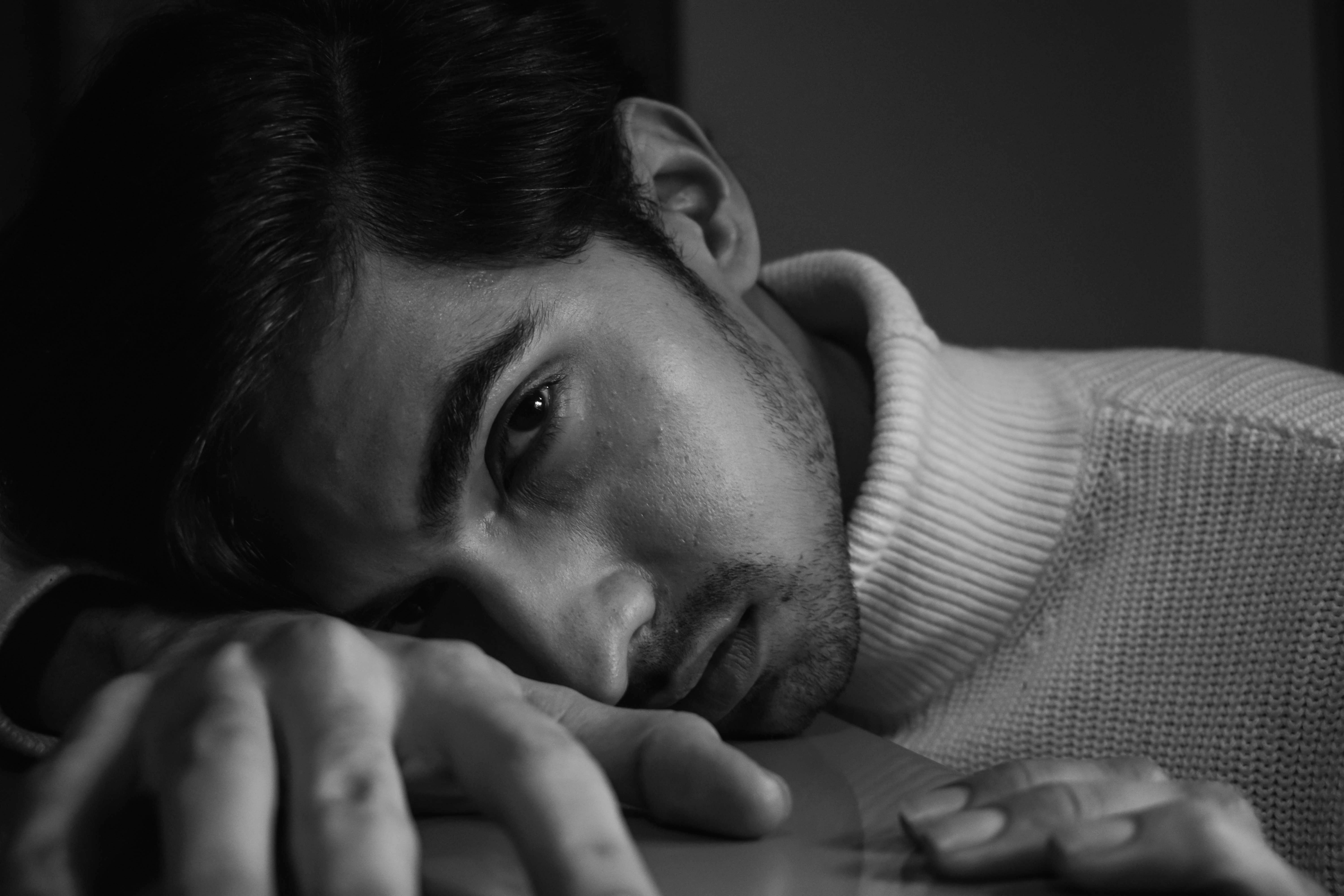 A thoughtful, monochrome portrait of a man in a turtleneck sweater.