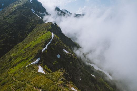 Fog drifting over a lush green mountain ridge — photo by Yaroslav Shuraev on Pexels