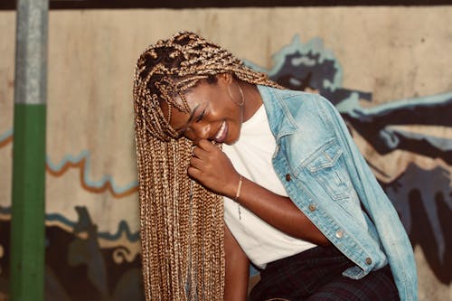 Free Joyful black woman laughing and touching face on street Stock Photo