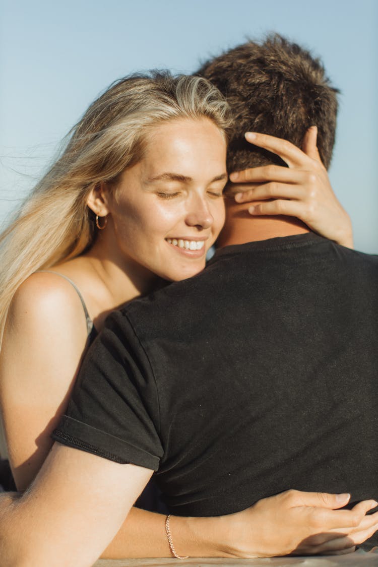 Smiling Woman Hugging A Man