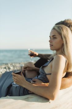 日落时分，情侣们在海边喝着葡萄酒，享受浪漫时刻