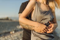 日落时分，一对浪漫的情侣在海滩上拥抱，捕捉到爱和温柔