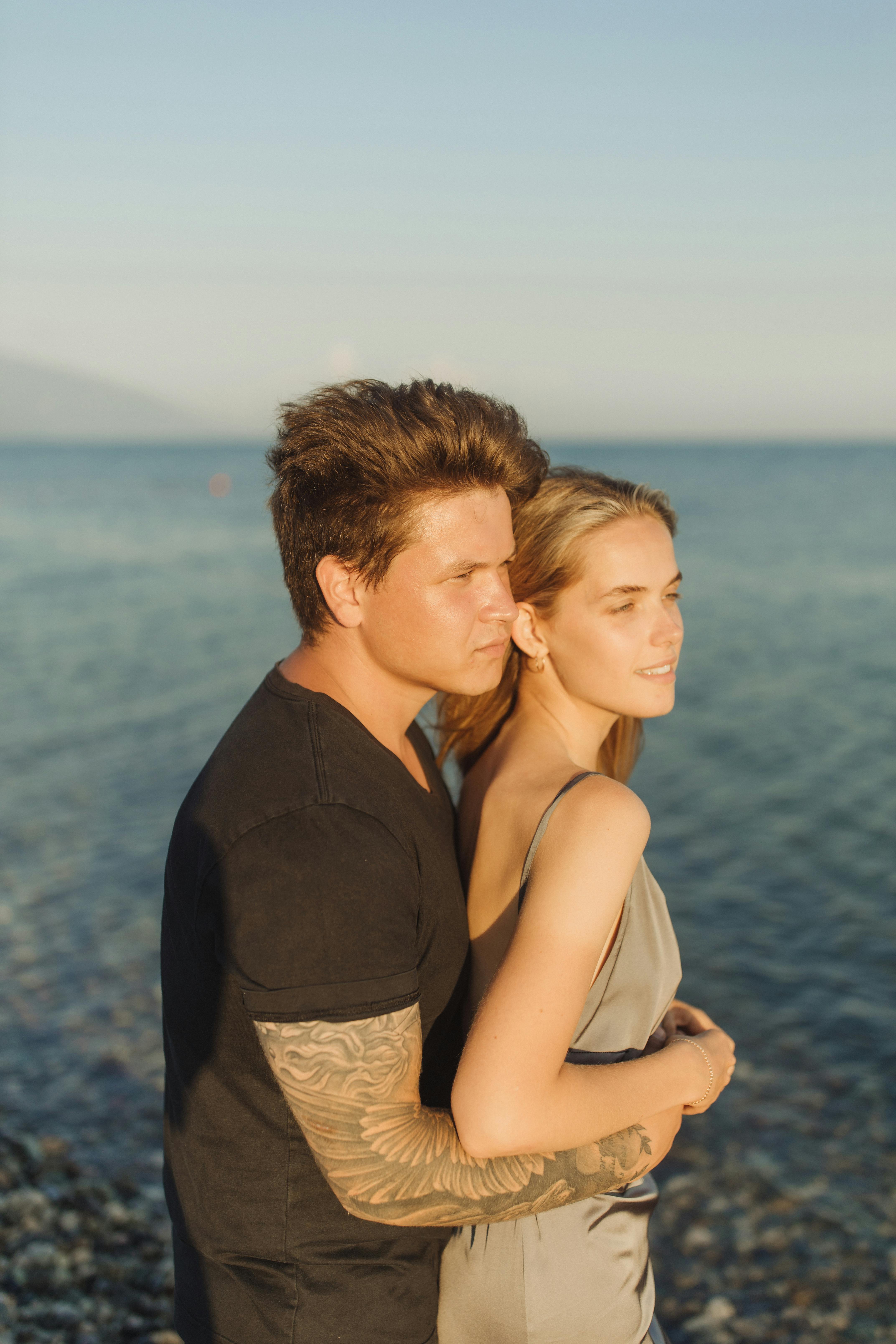 Man and Woman Kissing Near Body of Water · Free Stock Photo