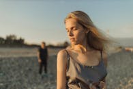 日落时分的宁静海滩上，一名女子手持酒杯，象征着浪漫