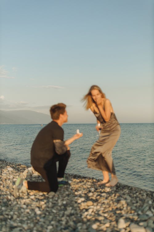 Man and Woman Standing on Rocky Shore