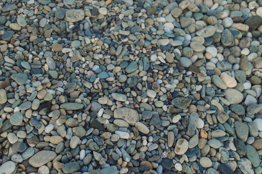 海滩上色彩缤纷、形态各异的鹅卵石特写，非常适合用作自然背景