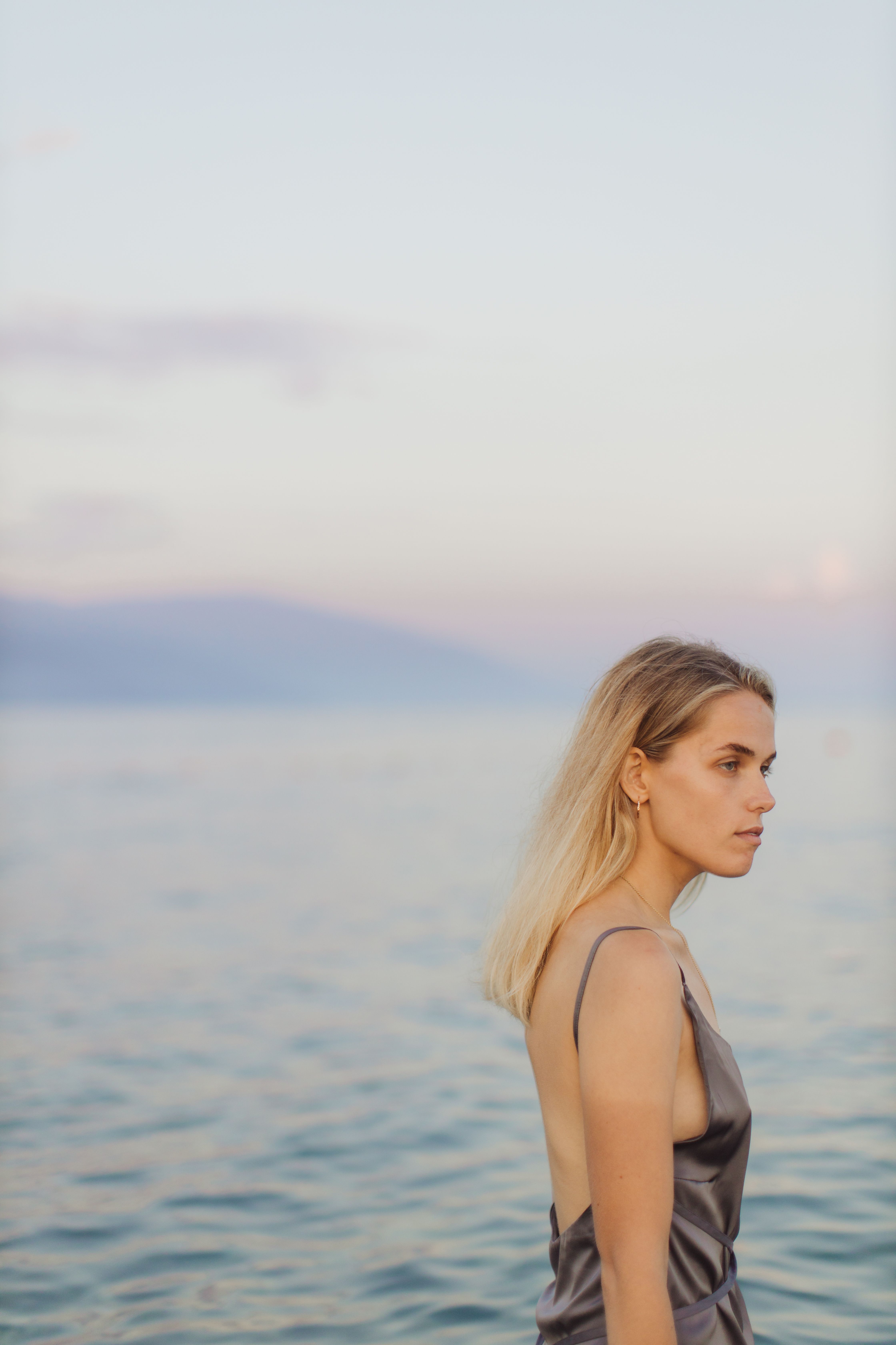 Woman in a Dress Standing Near Body of Water · Free Stock Photo