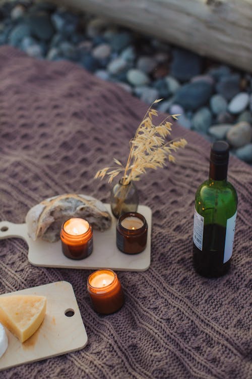 Green Glass Bottle Beside White Ceramic Mug on Brown Wooden Table