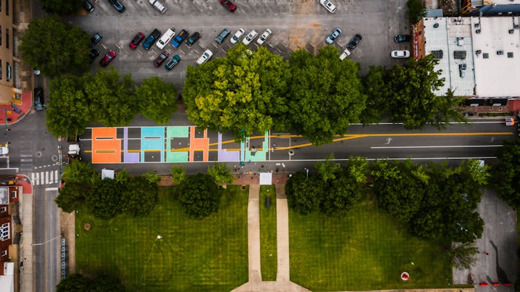 Bright Road Near Lawn With Trees And Public Parking