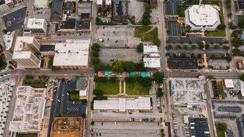 Free Drone view of building roofs near roadway with bright Black Lives Matter inscription near city parking with vehicles in daylight Stock Photo