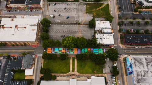 Free Aerial view of building roofs near roadway with colorful BLM title and lawn with trees in town in summer Stock Photo