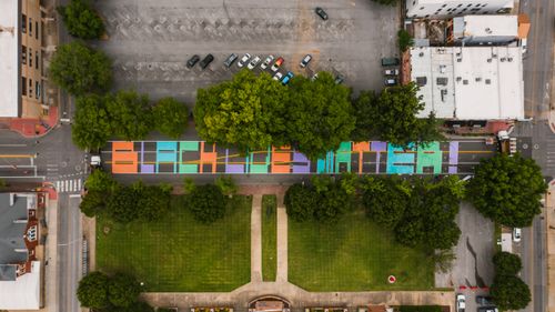 Free Top view of road with bright BLM title near lawn with trees and public parking in city Stock Photo